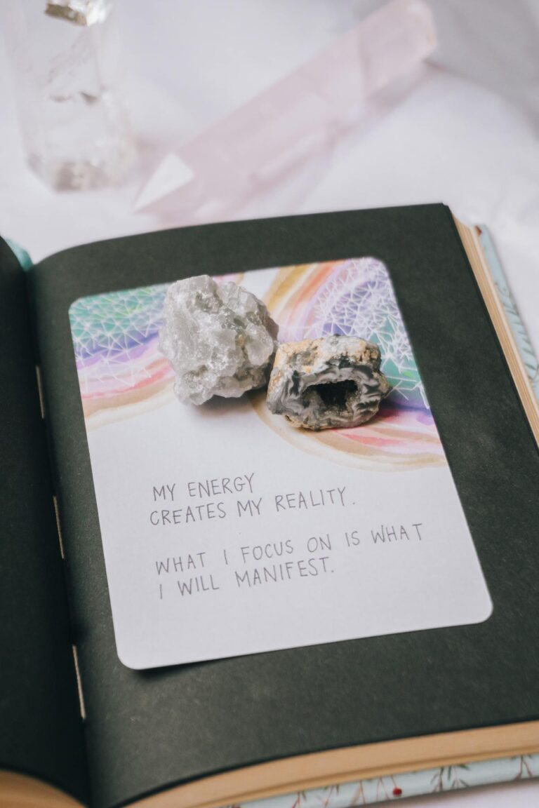 Open journal featuring crystals and an inspiring manifestation quote, perfect for motivation seekers.